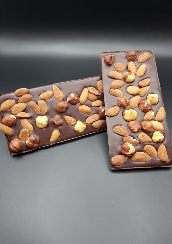 Tablette de chocolat noir aux amandes et noisettes, un délice croquant et riche.
